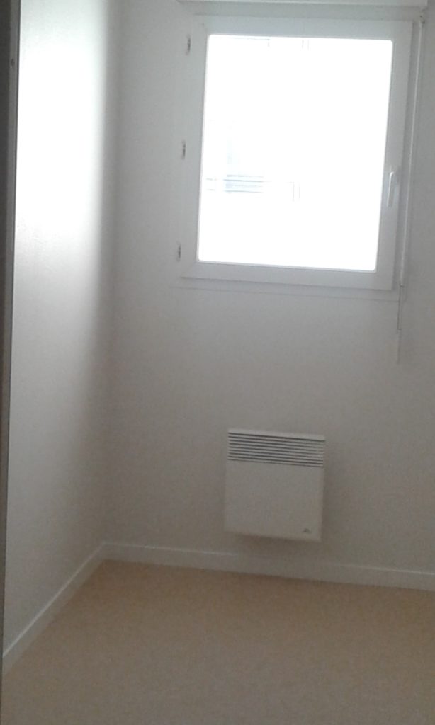 Mur avec fenêtre et radiateur entièrement repeint en blanc